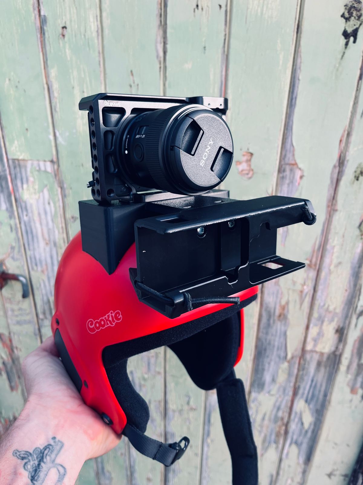 A 3D-printed camera cage mount on a red Cookie helmet